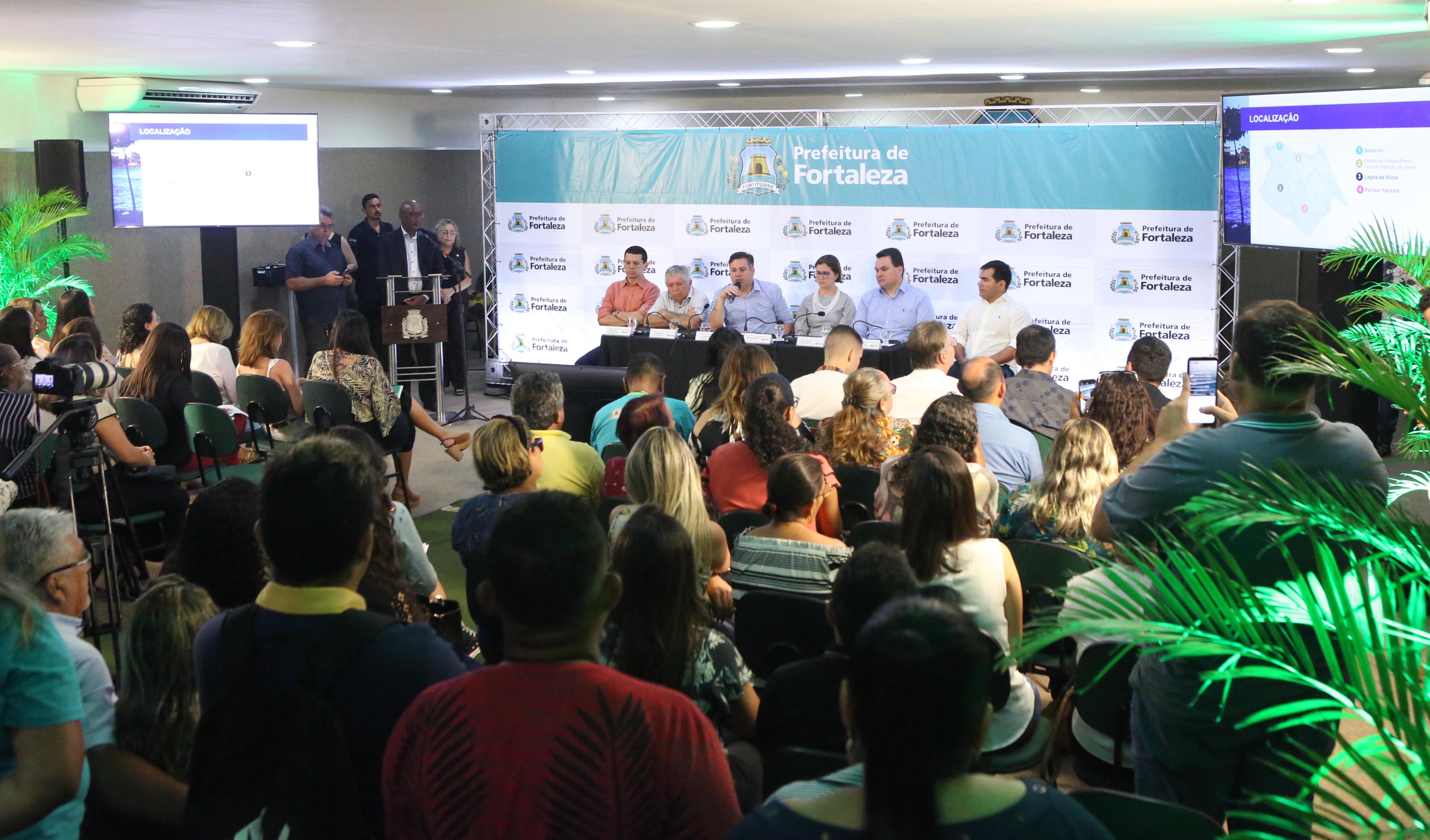 grupo de pessoas sentadas numa mesa de auditório